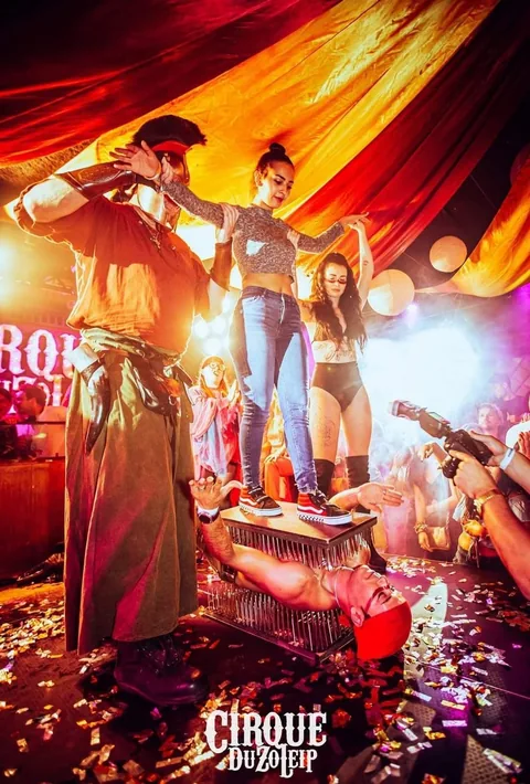 Spectator standing on the bed of nails on Nuno during a spectacular circus night with confetti
