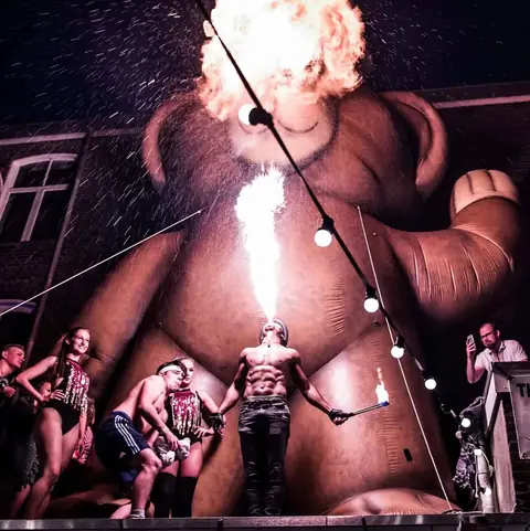 Fire breather Nuno blows a fireball on a festival square for a large crowd