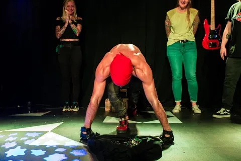 Nuno resting his hands in broken glass during a theatre show