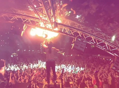 Nuno on the festival stage with fire above a cheering festival crowd